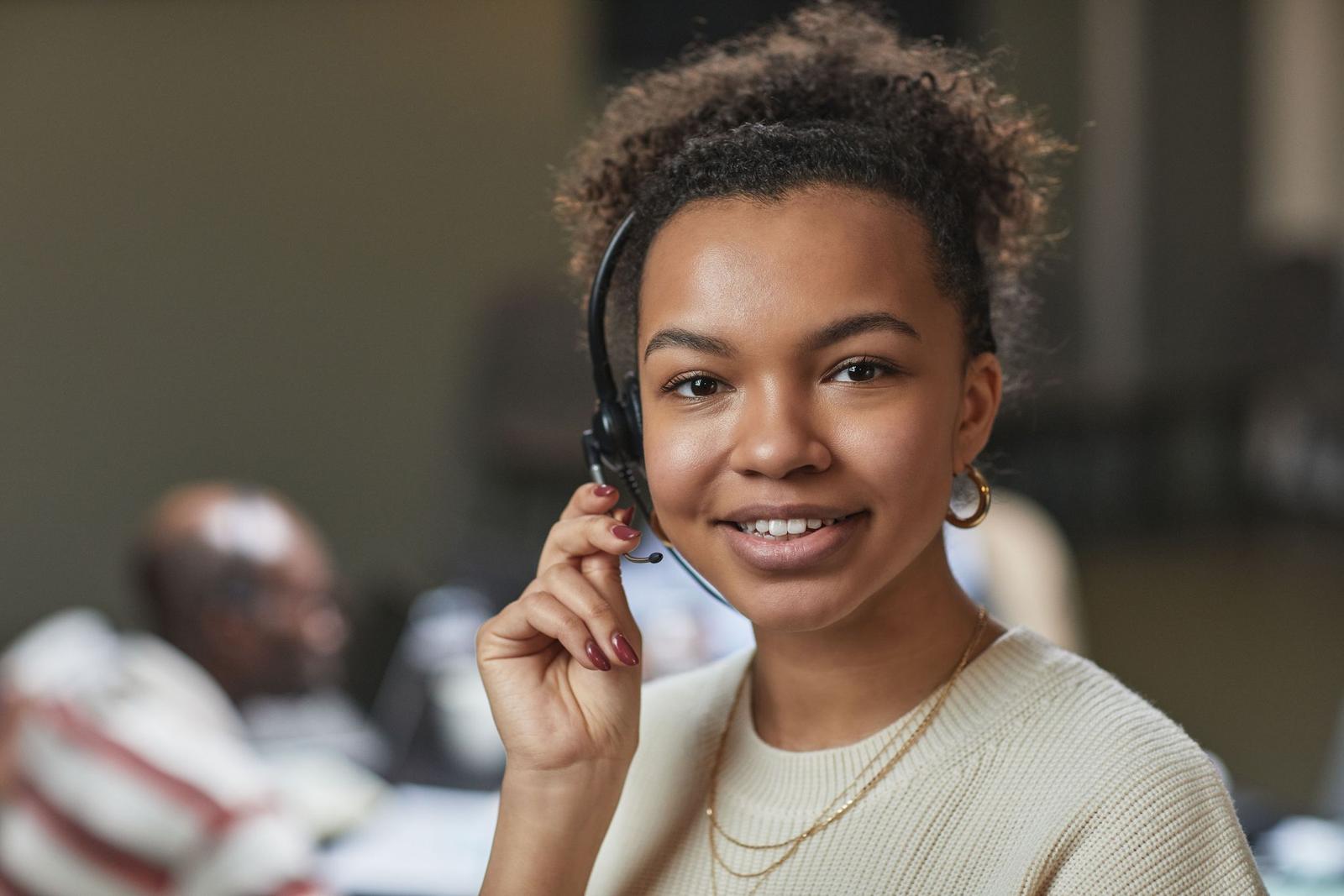 A case worker on a headset, smiling