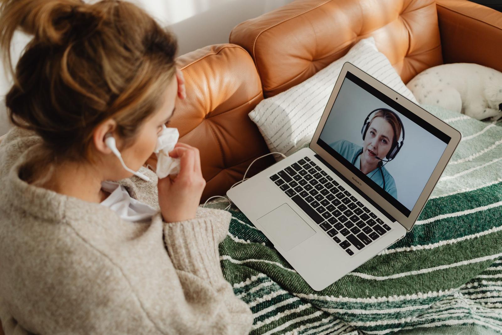A woman talks to a case worker on a video call from home